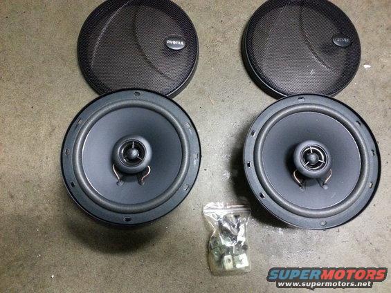 Two car speakers with grilles and a bag of mounting hardware