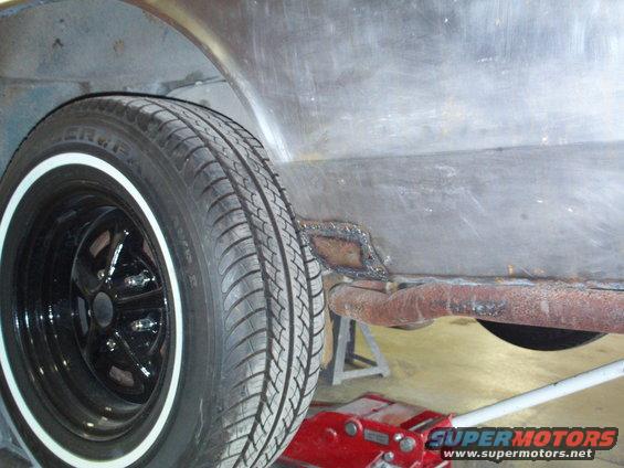 1973 Ford Ranchero side view showing wheel well, tire, and rusted metal panel with patch