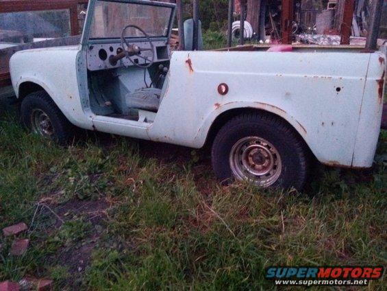 Light blue convertible SUV with doors removed, sitting in tall grass