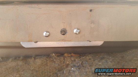 Interior panel with three screws and a metal bracket, text 'SIMPSON' visible on bracket