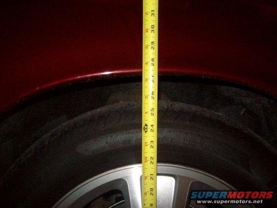 Measuring the gap between tire and fender with a tape measure