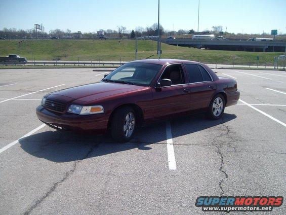 Maroon sedan parked in a lot. It looks like a 2004 Ford Crown Victoria