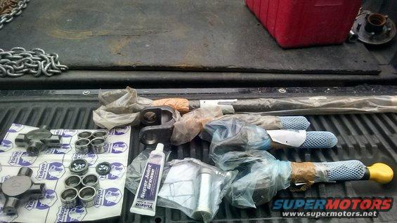 Yukon driveshaft parts and Super Joint Grease laid out on a truck bed. Includes U-joints and bearing caps