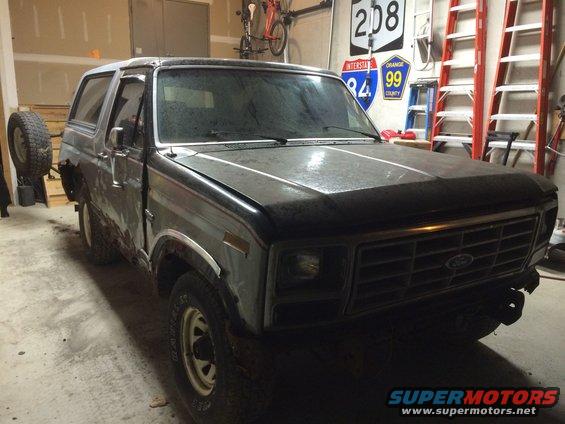 Ford Bronco with a spare tire mounted on the rear, parked in a garage