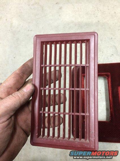Red plastic vent held by a hand