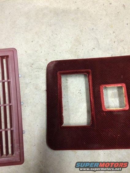 Maroon vent and a maroon dashboard trim piece with cutouts for controls