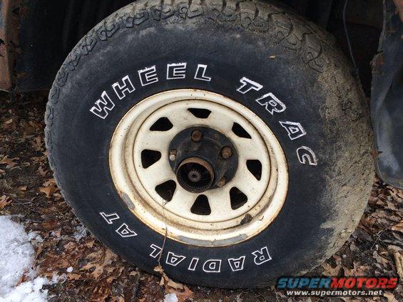 Close-up of a tire with 'WHEEL TRAC' and 'RADIAL AT' written on it, mounted on a white rim
