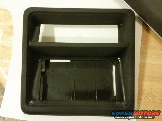 Black plastic dashboard trim piece with two rectangular openings