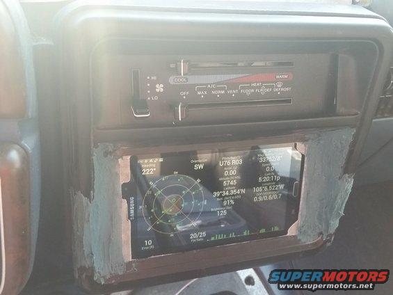 Dashboard interior showing aftermarket GPS unit with compass and coordinates