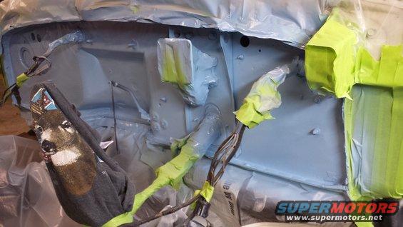 Engine bay covered in protective plastic and tape, with a deer-patterned cloth draped over wiring
