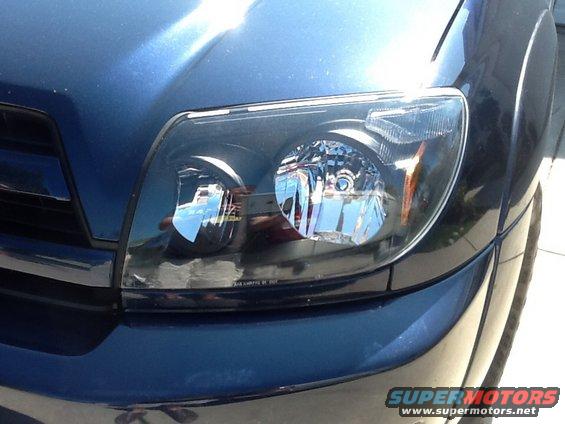 Front headlight assembly on a dark blue 2005 Toyota 4Runner