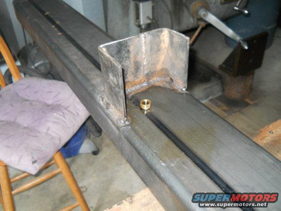 Metal frame with welded bracket and brass fitting, close-up