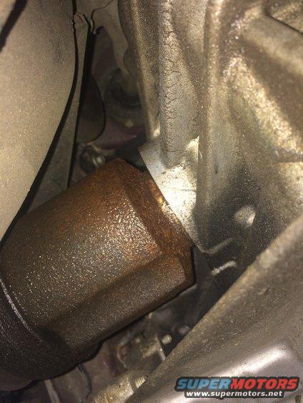Close-up of a rusty CV shaft and seal assembly, likely from a vehicle's drivetrain