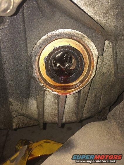 Close-up of a leaking transmission seal with fluid visible