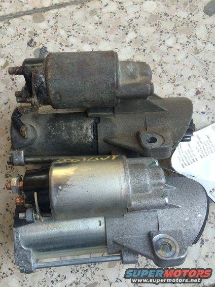 Two starter motors, one older and rusty, the other newer and cleaner. A label is visible on the newer one