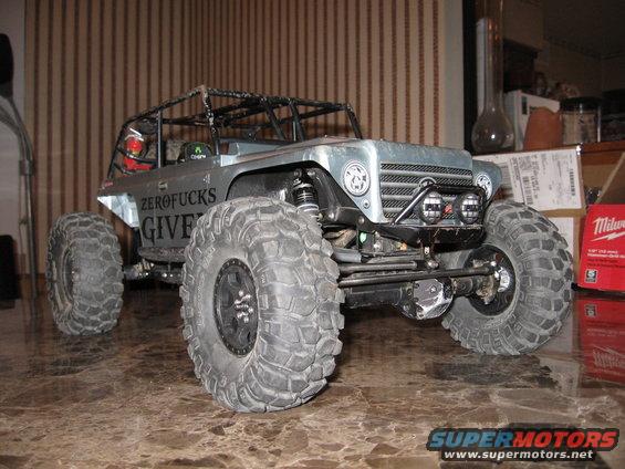 RC rock crawler toy with big tires and a roll cage. It has 'ZEROFUCKS GIVE' written on the side