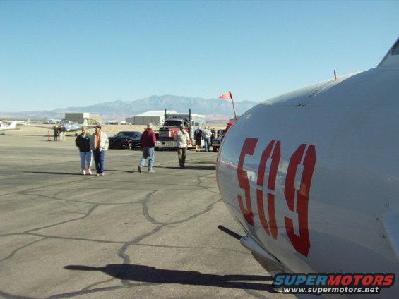 White aircraft fuselage with red '509' numbers, Peterbilt truck in background