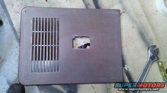 Brown vent grille with vertical slats and a rectangular cutout in the center. Adjustable wrench and screwdriver nearby