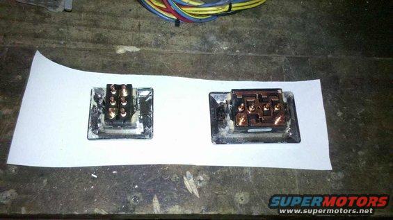 Two electrical connectors with copper terminals sit on white paper. Wires are visible in the background