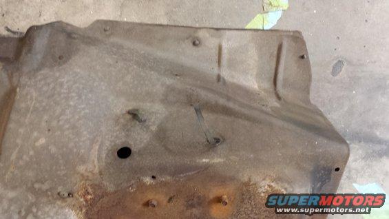 rusted metal underbody shield with bolt holes