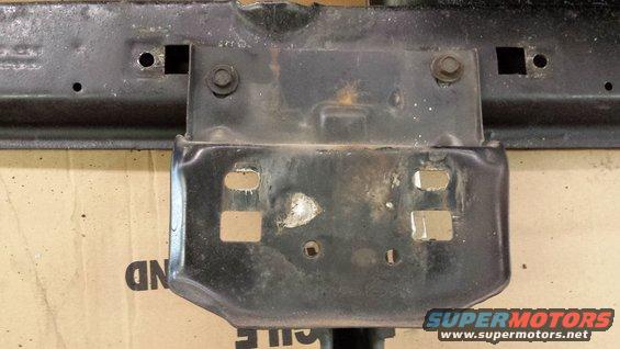 Close-up of a black metal vehicle frame bracket with mounting holes