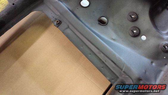 Close-up of vehicle frame with mounting points and holes