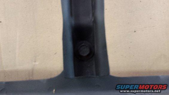 Black plastic trim piece with bolt