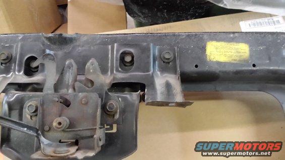 Hood latch mechanism with yellow sticker and Supermotors logo