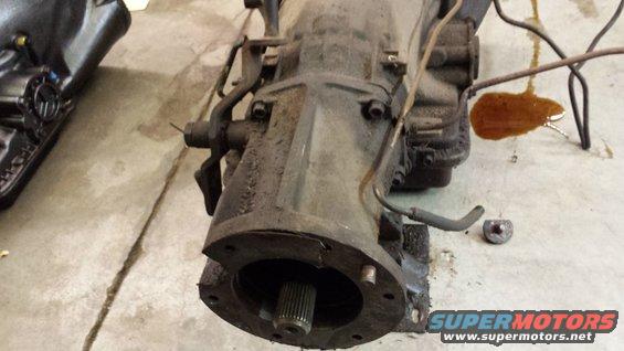 close-up of a transmission assembly with some fluid spilled on the concrete floor