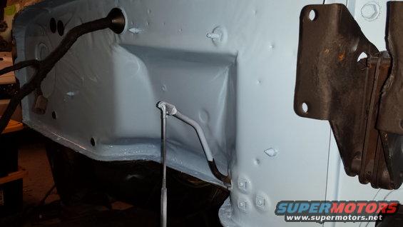 Light blue painted inner fender well with wiring harness and metal bracket