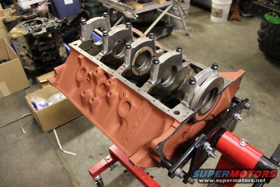 Engine block on a red stand, ready for assembly. Another engine block is visible in the background