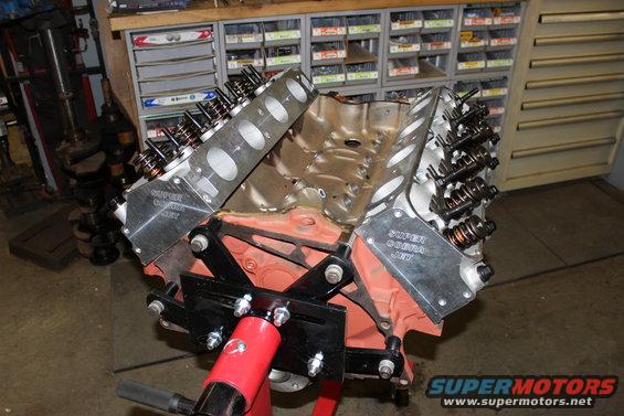 Engine block with "Super Cobra Jet" valve covers on an engine stand in a workshop