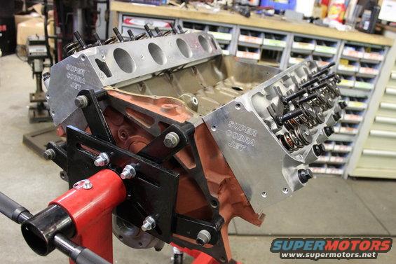 Engine block with "Super Cobra Jet" lettering on a red stand, viewed from the side