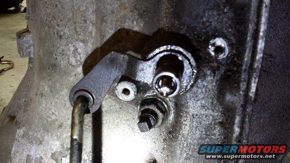Close-up of a transmission linkage mechanism with oil residue