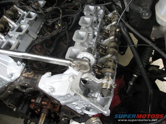 Engine with torque wrench on valve cover bolts