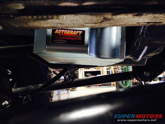 Underside view of a new aluminum oil pan with an AUTOKRAFT label, attached to a vehicle's chassis