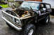 1979 Ford Bronco - Front view of a 1979 Ford Bronco undergoing engine work, with the hood and engine removed.