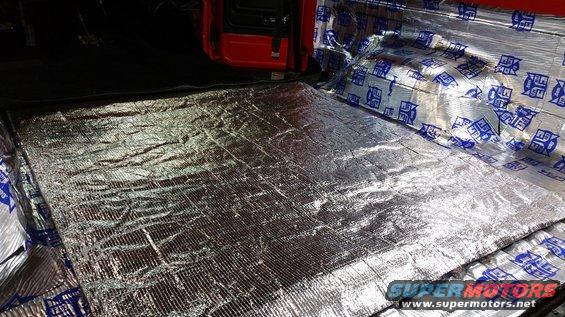Interior sound deadening material covering the floor and rear cargo area of a red vehicle