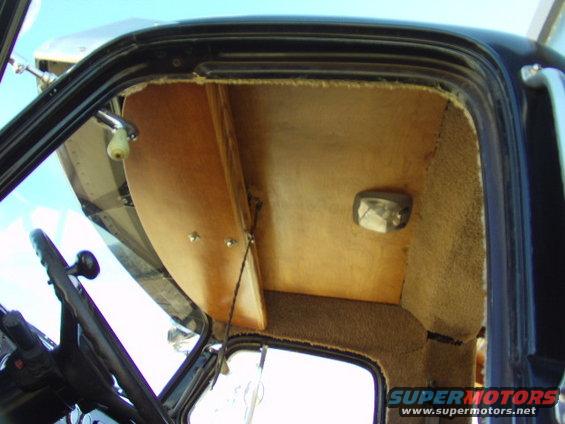 Interior view of a truck cab showing the headliner, door panel, and steering wheel