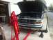 1993 Ford Bronco - Ford Bronco undergoing maintenance with hood open and engine exposed, engine hoist positioned for work.