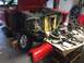 1964 Ford Fairlane - Car parts are organized on a table next to a disassembled vehicle in a garage.