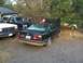 1988 BMW 7 Series - A black 1988 BMW 7 Series sedan sits with its hood open, parked next to other vehicles.