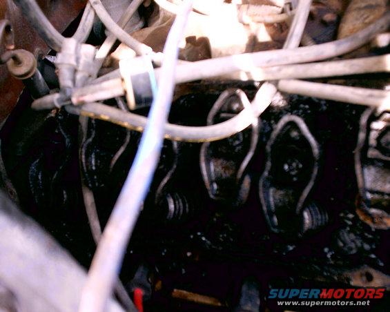 Engine valve train with oil residue and hoses. Supermotors.net logo visible