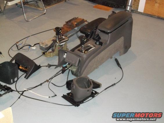 Disassembled interior console and steering column parts on floor