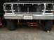 1978 Ford Bronco - The front end of a Ford truck is shown, missing its grille and headlights, revealing the radiator and suspension components.