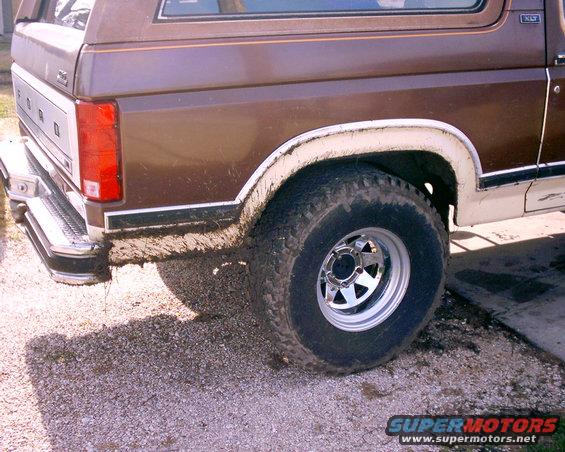 1980 Ford Bronco rear quarter panel and tire covered in mud