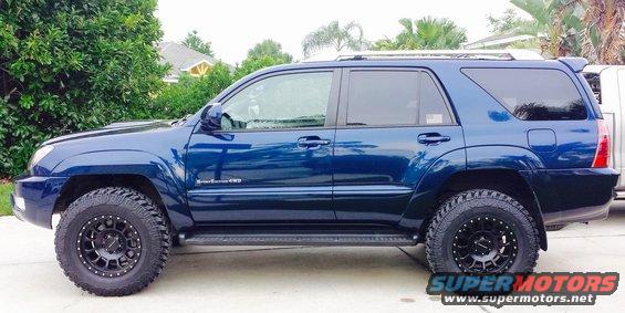 Blue Toyota 4Runner with black aftermarket wheels and tires, lifted suspension, and roof rack