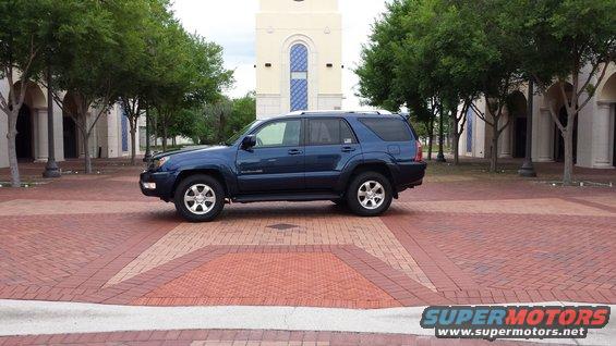 Blue 2005 Toyota 4Runner parked on a brick patio in front of a building with arched windows