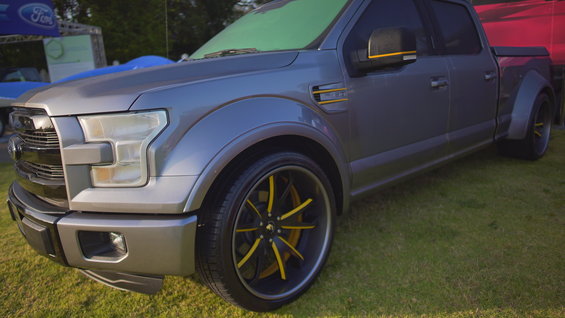 Gray Ford F-150 pickup truck with custom yellow-accented wheels and mirrors
