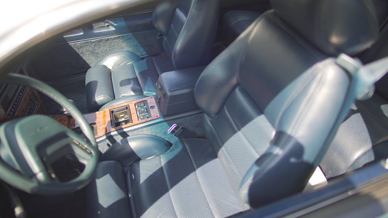 1995 Ford Taurus interior with dark blue leather seats, wood trim, and a steering wheel